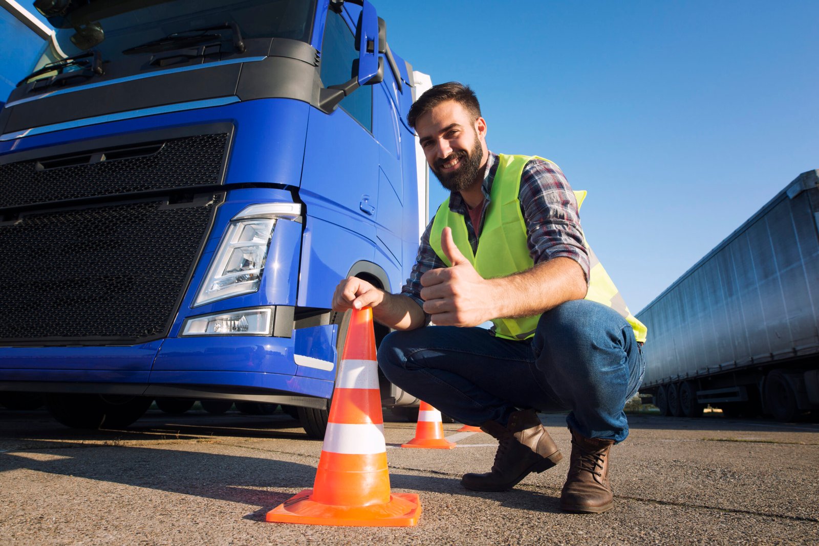 Hombre usando chaleco de prevención junto a un cono de vialidad
